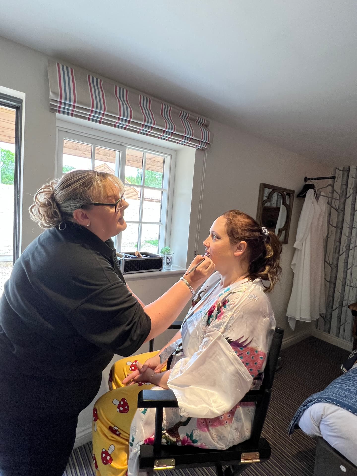 Kirsty Emmerson applying lipstick to a bride on the wedding morning